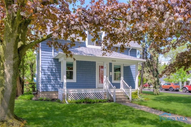 229 E Harrison St, Maumee, OH 43537 - bungalow-style home featuring a porch, a shingled roof, and a front yard