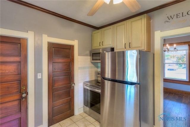 229 E Harrison St, Maumee, OH 43537 - kitchen with baseboards, ornamental molding, ceiling fan, stainless steel appliances, and cream cabinets