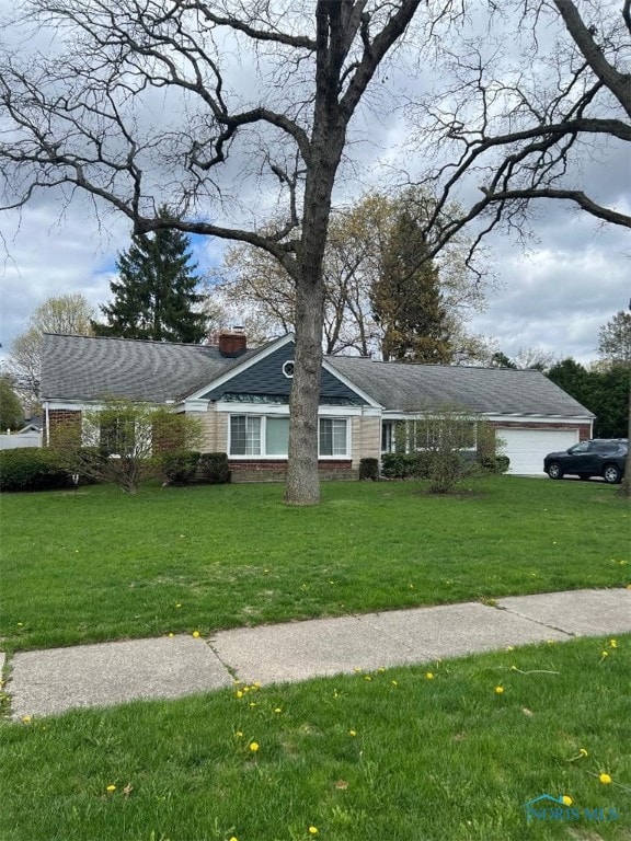 single story home featuring brick siding, a front lawn, and a chimney