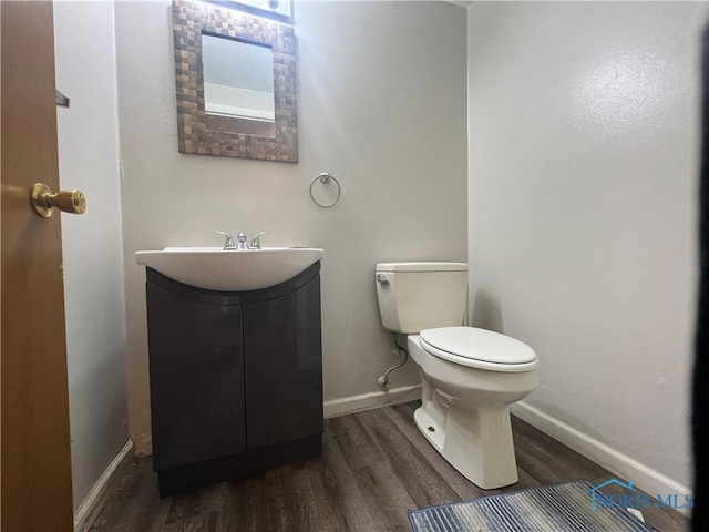 107 Oak Park Dr, Hicksville, OH 43526 - half bath featuring wood finished floors, vanity, toilet, and baseboards
