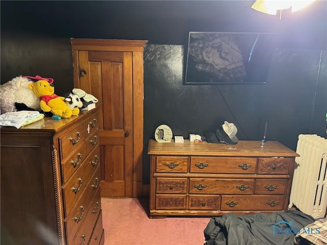 bedroom featuring light carpet and radiator heating unit