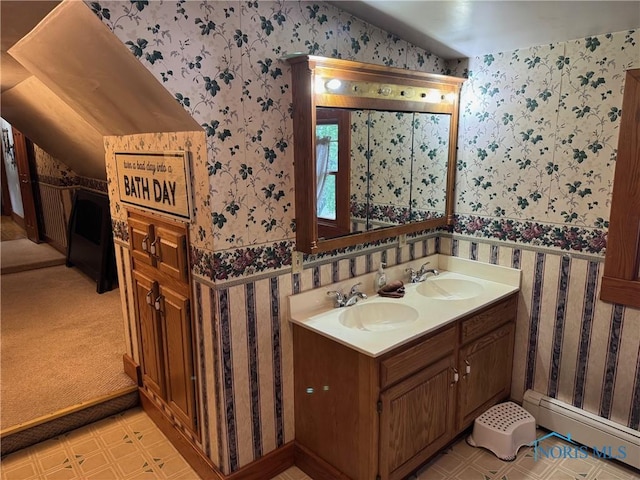 full bathroom featuring wallpapered walls, vaulted ceiling, a baseboard radiator, and a sink