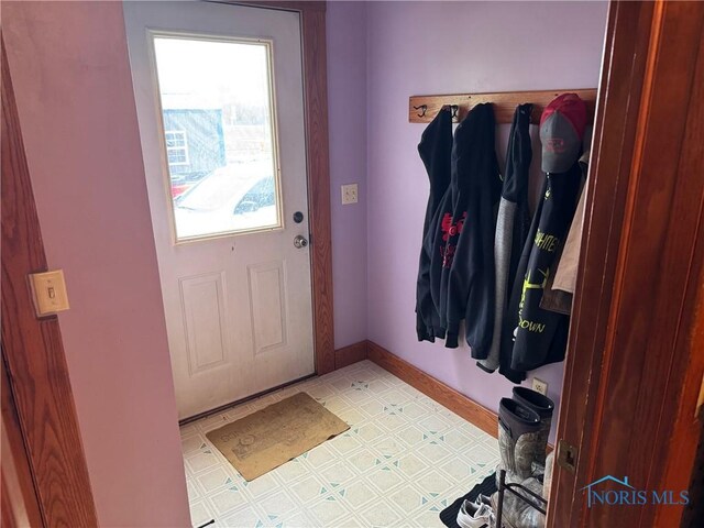 entryway with baseboards and light floors