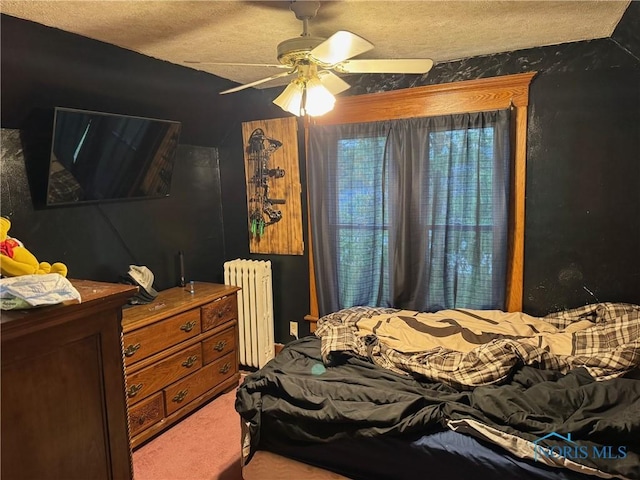 carpeted bedroom featuring a textured ceiling, ceiling fan, and radiator heating unit