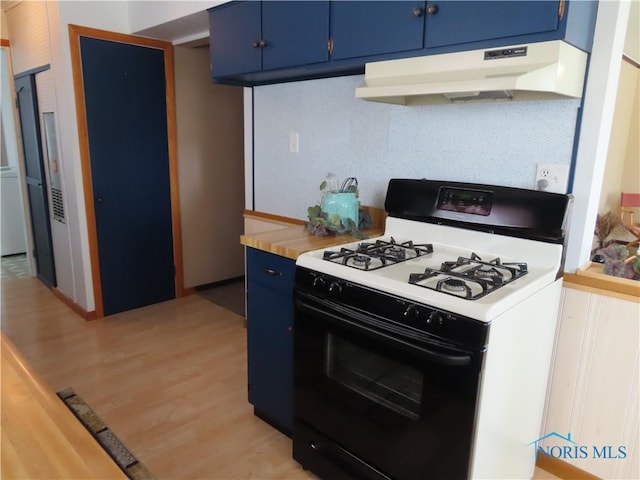 kitchen with light wood-style flooring, gas range oven, under cabinet range hood, light countertops, and blue cabinets