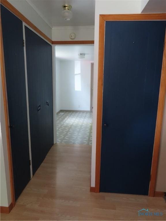 corridor with crown molding and baseboards