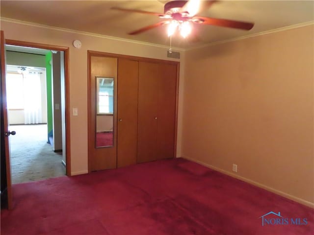 unfurnished bedroom featuring ornamental molding, carpet flooring, a closet, and baseboards