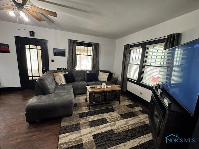 living area with baseboards, wood finished floors, and a ceiling fan