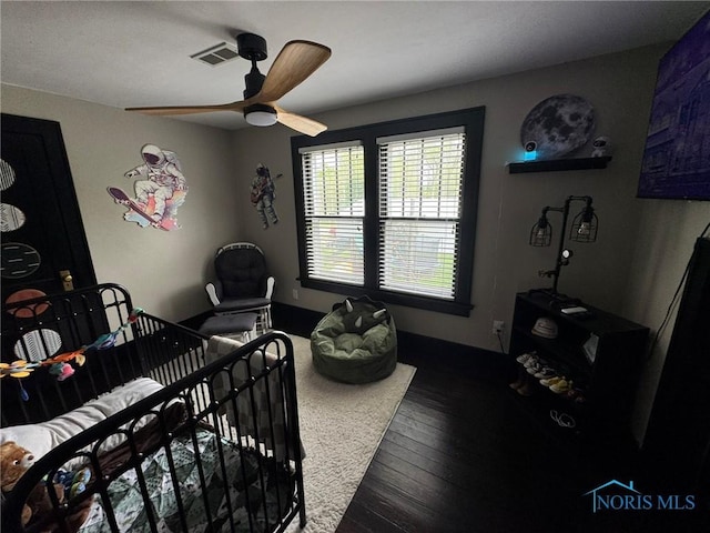 bedroom featuring visible vents, a ceiling fan, and hardwood / wood-style floors