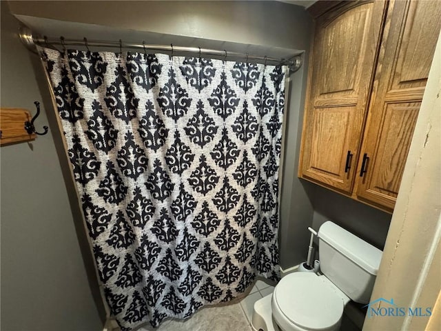 full bathroom featuring toilet, tile patterned floors, and curtained shower