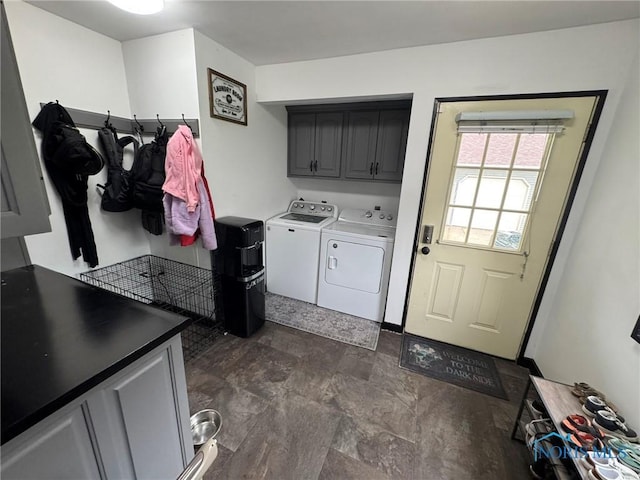 washroom featuring stone finish flooring, cabinet space, and independent washer and dryer