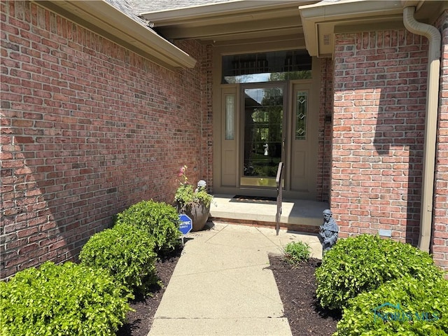 doorway to property with brick siding