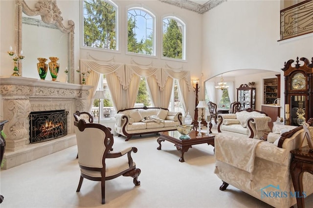 4854 Cinnamon Ln, Sylvania, OH 43560 - living room featuring a towering ceiling, carpet floors, arched walkways, a premium fireplace, and a chandelier