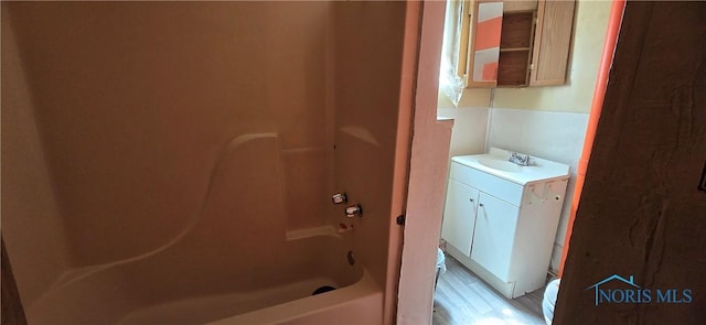 bathroom featuring vanity, shower / washtub combination, and wood finished floors
