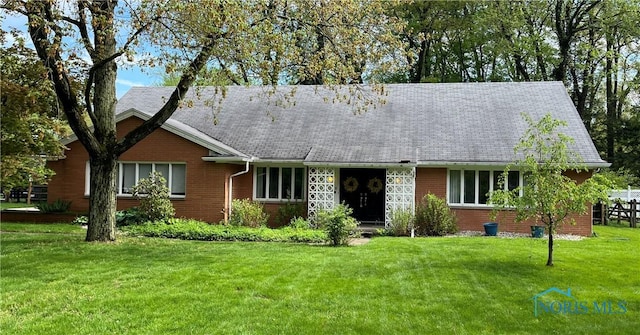single story home featuring a front lawn and brick siding