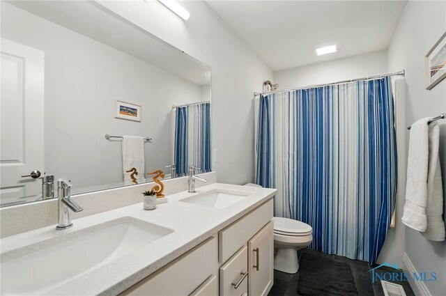 full bath featuring toilet, double vanity, and tile patterned floors