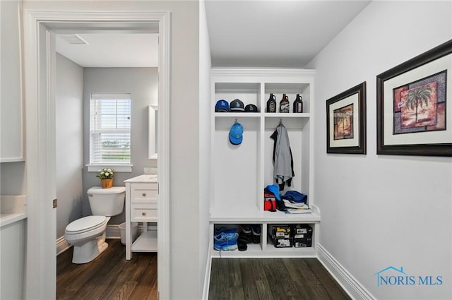 mudroom with dark wood finished floors and baseboards
