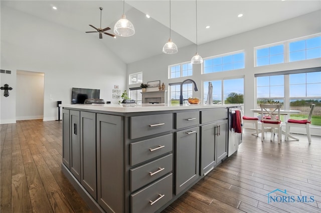 kitchen with gray cabinetry, high vaulted ceiling, dark wood finished floors, open floor plan, and light countertops