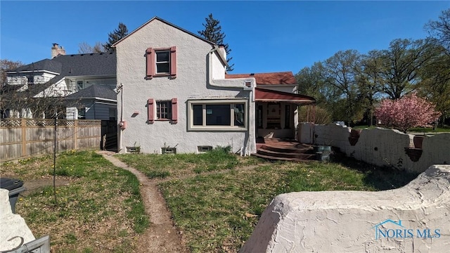 back of house with fence and stucco siding