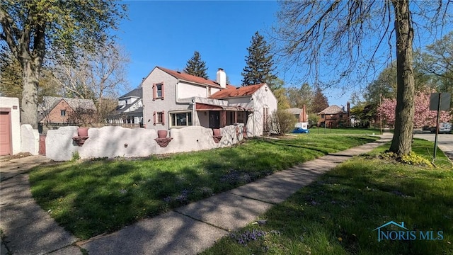 view of property exterior with a yard and a chimney