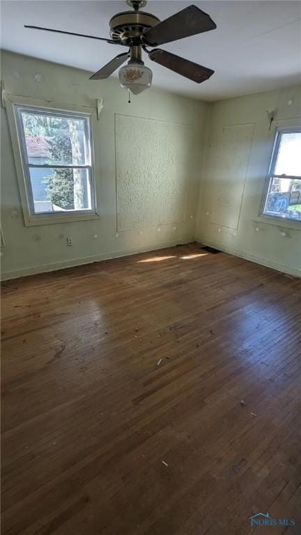 spare room featuring dark wood finished floors, baseboards, and a ceiling fan