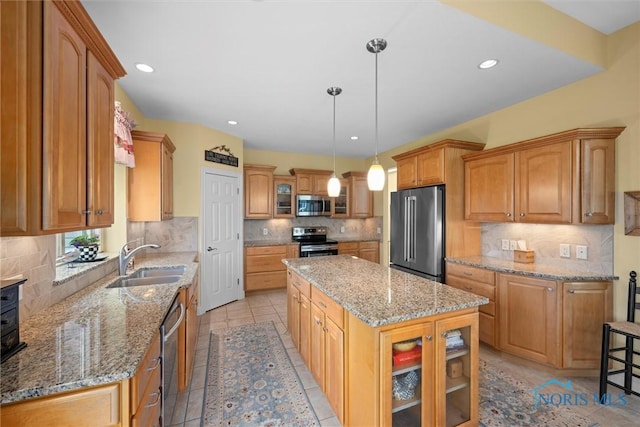 kitchen featuring a sink, tasteful backsplash, a center island, glass insert cabinets, and appliances with stainless steel finishes