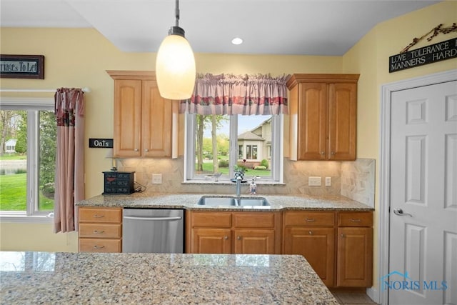 kitchen with backsplash, dishwasher, light stone countertops, and a sink
