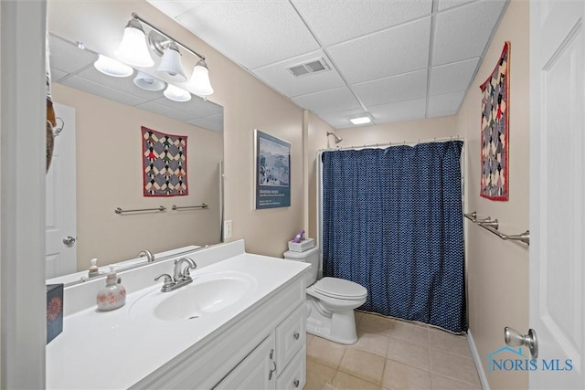 bathroom featuring toilet, a paneled ceiling, tile patterned floors, visible vents, and vanity