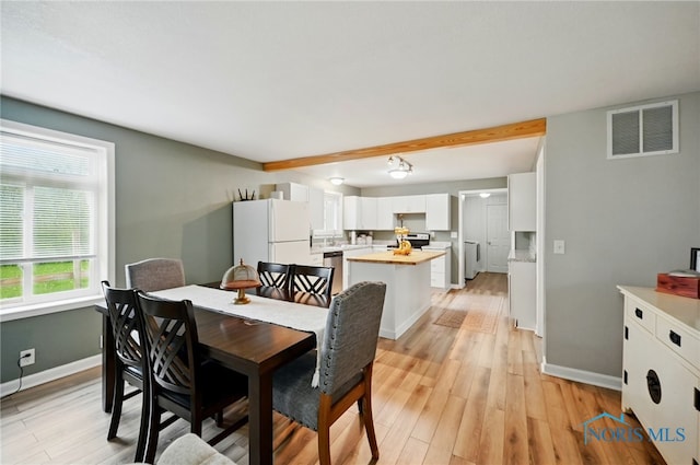 dining room with light wood-style floors, visible vents, and baseboards