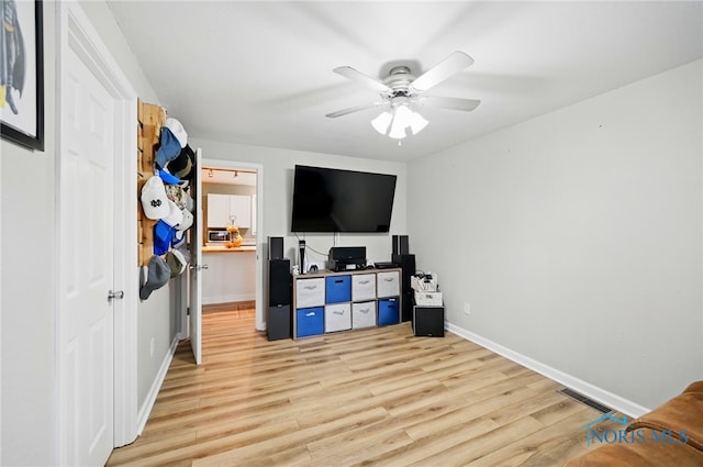interior space featuring baseboards, light wood finished floors, visible vents, and a ceiling fan