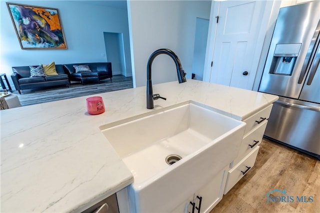 15043 Hickory Creek Ct, Perrysburg, OH 43551 - kitchen featuring white cabinetry, light stone counters, stainless steel fridge with ice dispenser, and a sink