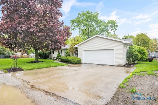 view of front facade featuring a garage, a front yard, and driveway