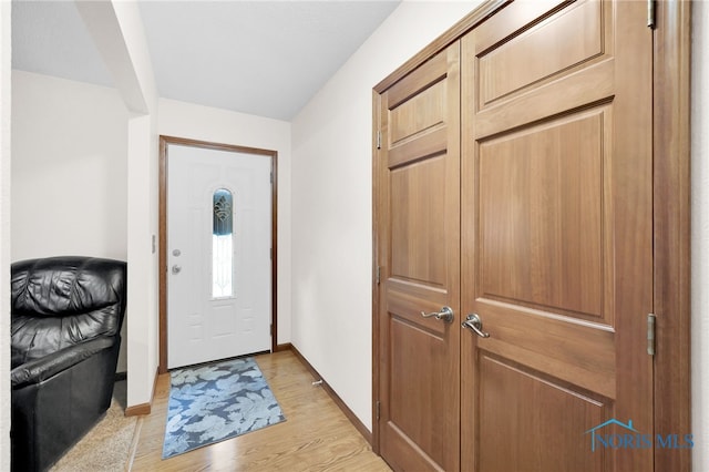 foyer with baseboards and light wood finished floors
