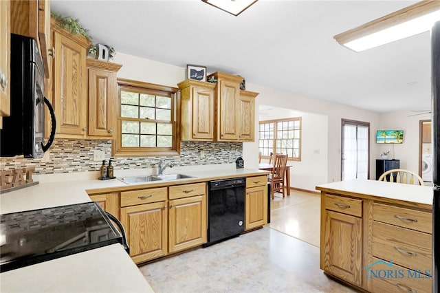 kitchen featuring black appliances, backsplash, a sink, and plenty of natural light
