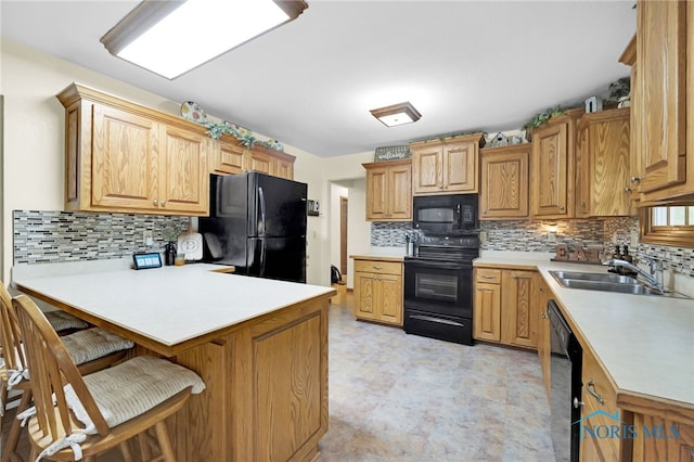 kitchen with black appliances, a sink, a peninsula, and tasteful backsplash