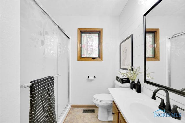 full bath featuring a shower stall, vanity, toilet, and baseboards
