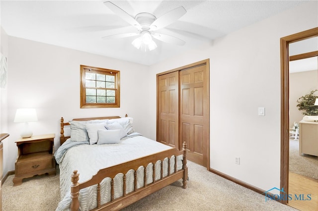 bedroom featuring light colored carpet, a closet, baseboards, and ceiling fan