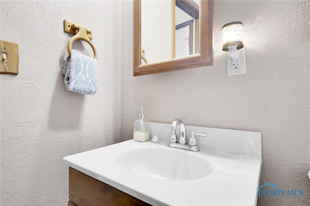 bathroom featuring vanity and a textured wall