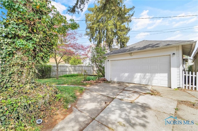 detached garage featuring fence
