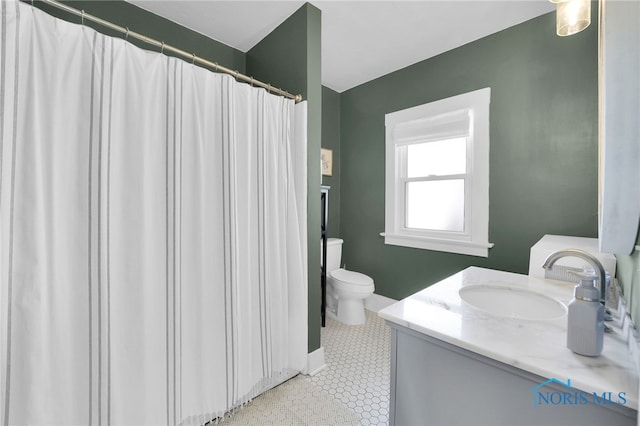 bathroom with toilet, baseboards, and vanity