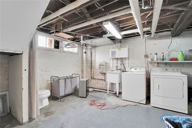 basement with a sink and independent washer and dryer