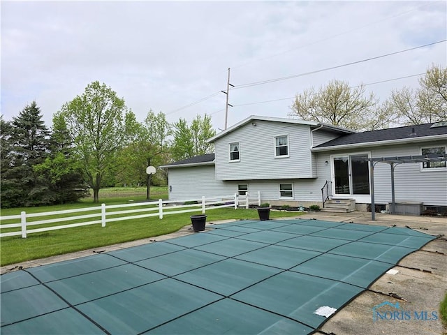 view of swimming pool featuring entry steps, a fenced in pool, fence, and a lawn