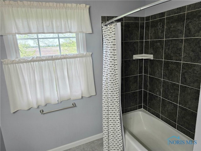 full bathroom with baseboards and shower / bath combo with shower curtain