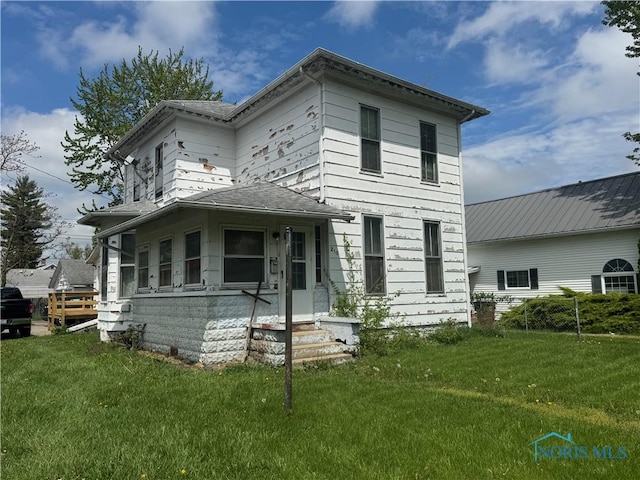 view of front facade with a front yard and fence