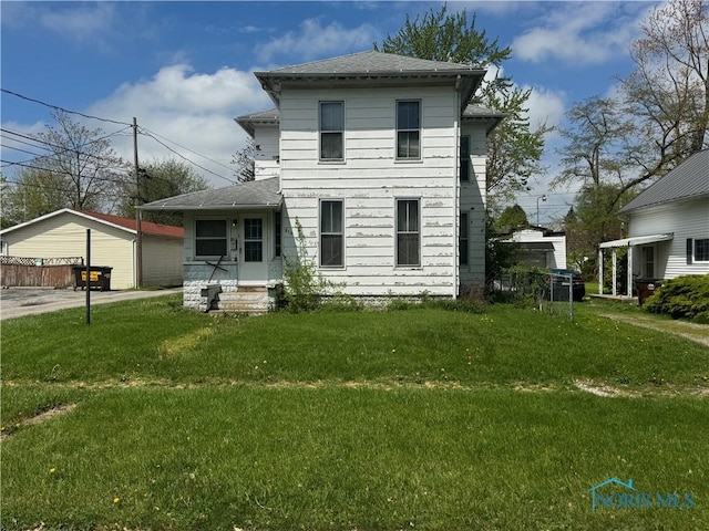 view of front of property featuring a shingled roof and a front lawn