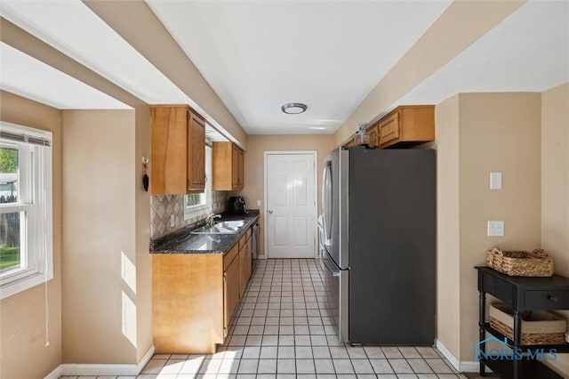 4410 Margrete Dr, Maumee, OH 43537 - kitchen with freestanding refrigerator, a sink, dark countertops, and healthy amount of natural light