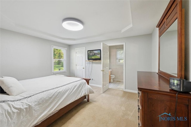 4410 Margrete Dr, Maumee, OH 43537 - bedroom featuring light colored carpet, a raised ceiling, baseboards, and connected bathroom