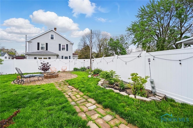 view of yard with a fire pit, a patio, a gate, and a fenced backyard