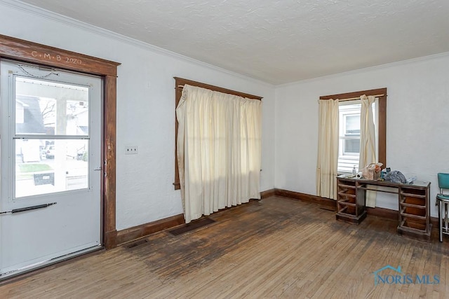 foyer entrance featuring baseboards, ornamental molding, and hardwood / wood-style flooring