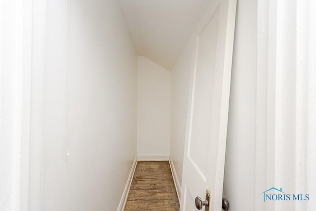interior space with baseboards, lofted ceiling, and wood finished floors